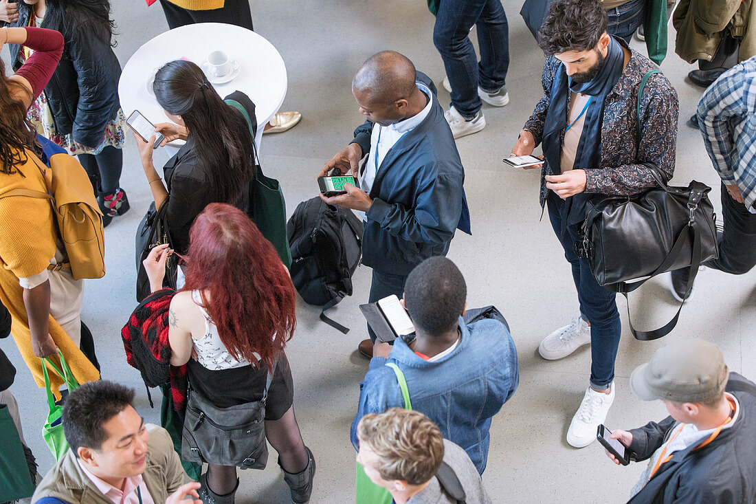 Business people using smart phones at conference