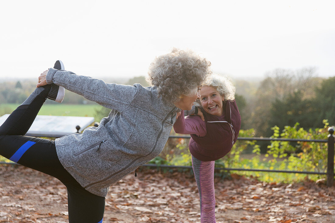 Active senior women friends stretching, practicing yoga