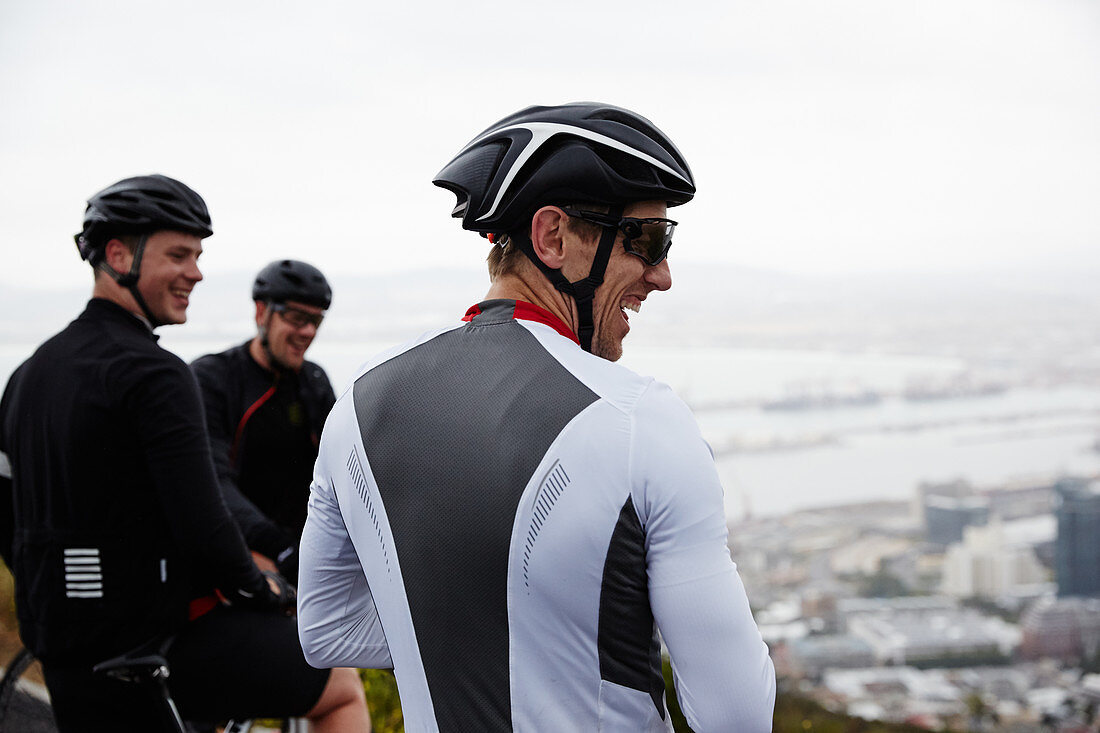 Smiling male cyclist friends taking a break