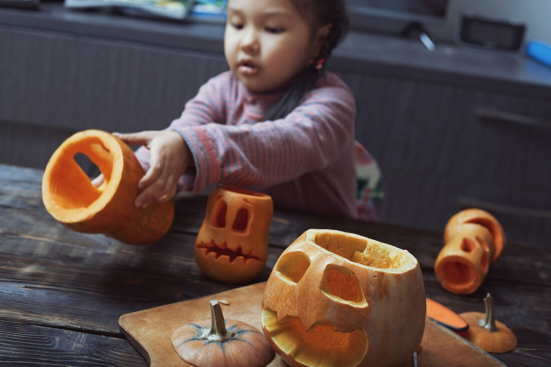 Girl carving Halloween pumpkins