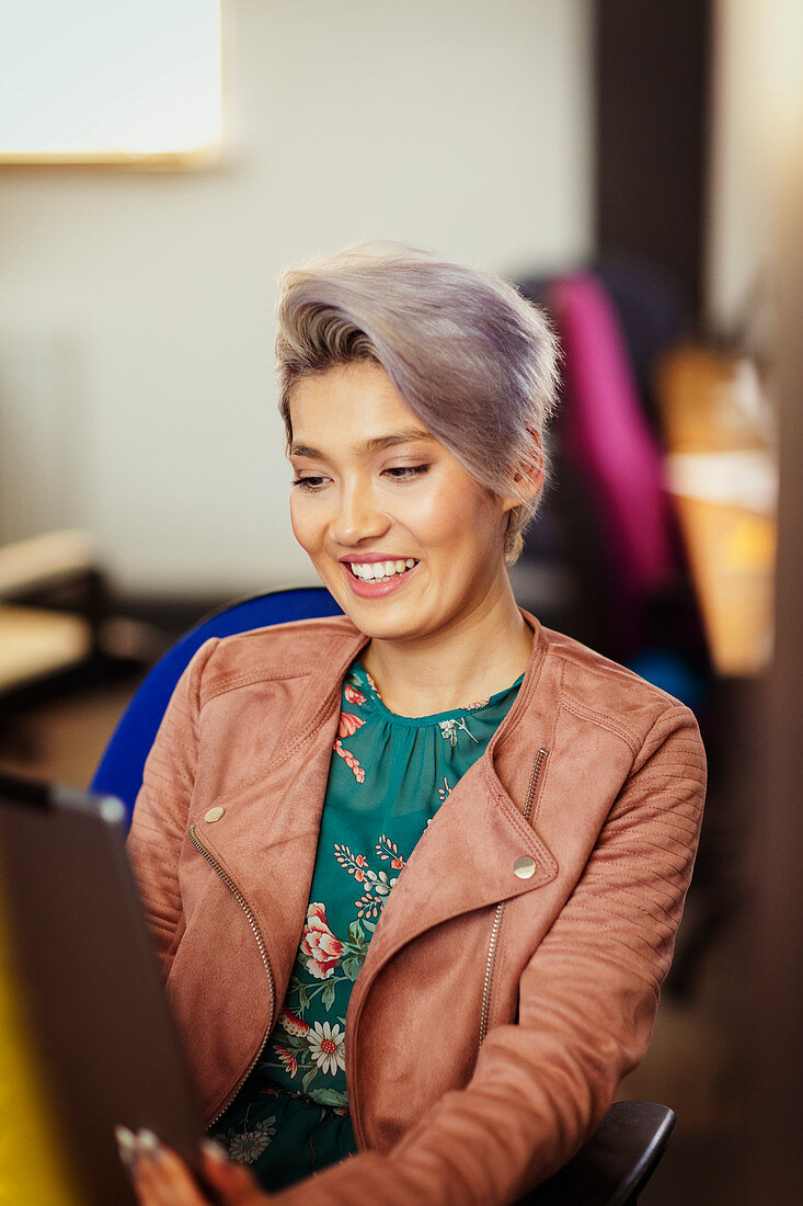 Smiling creative businesswoman using digital tablet