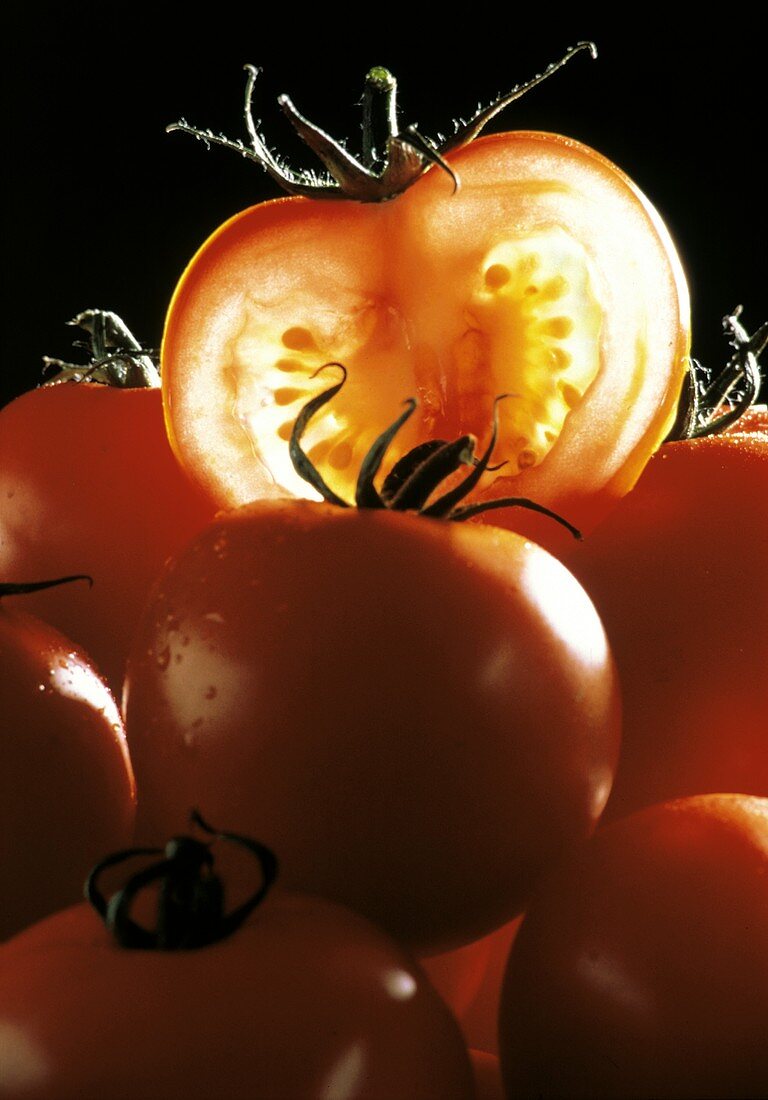 Tomaten auf Haufen, eine Tomatenscheibe obenauf