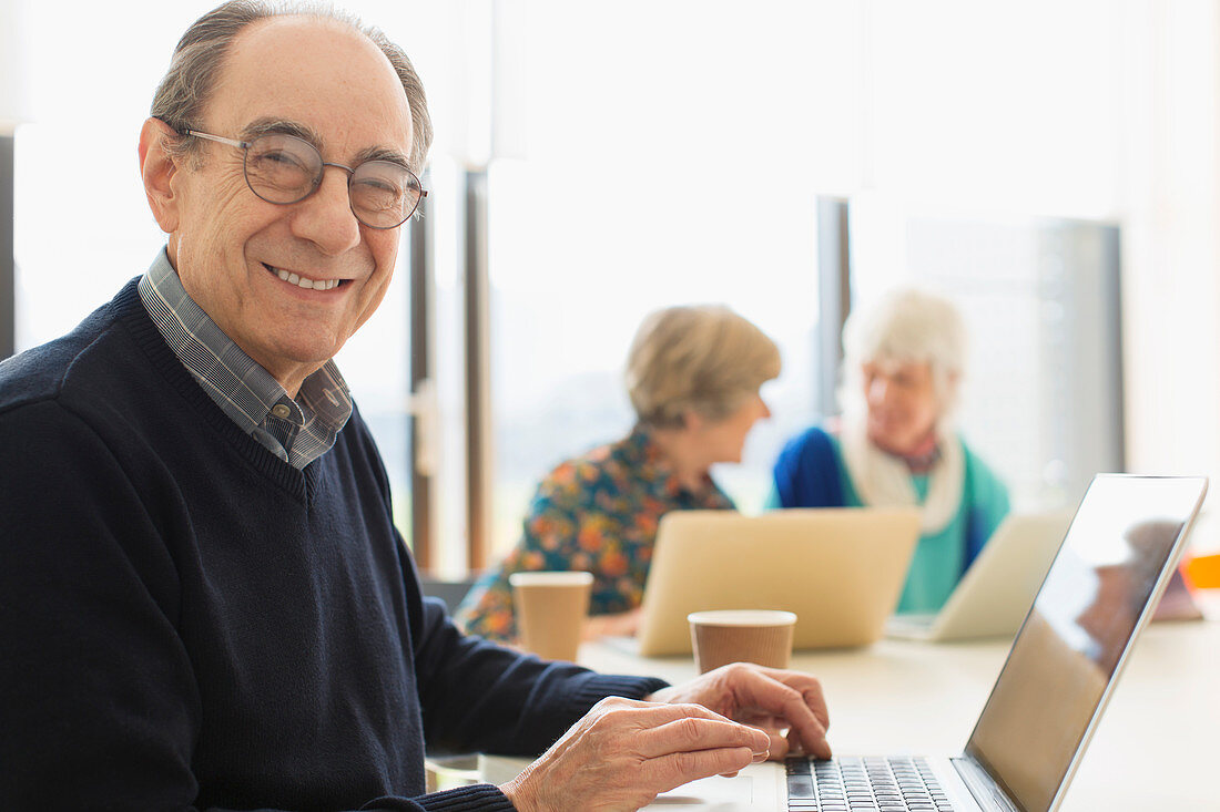 Portrait smiling senior businessman using laptop