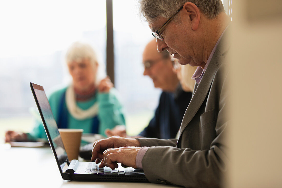 Focused senior businessman using laptop