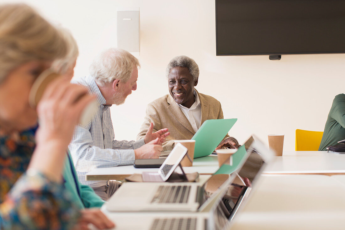 Senior businessmen using laptop in conference room meeting