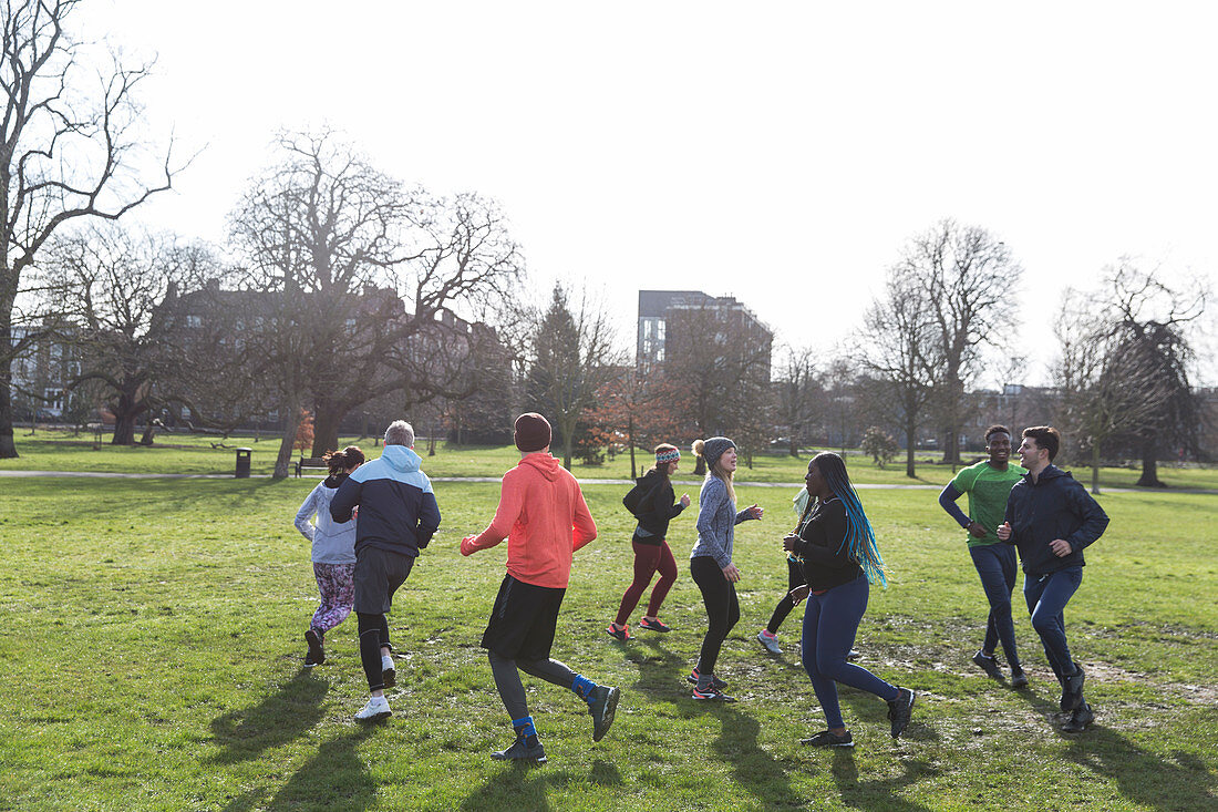 Runners jogging in circle in sunny park