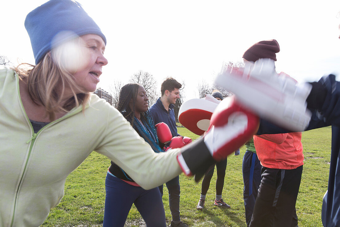 Determined senior woman boxing in park