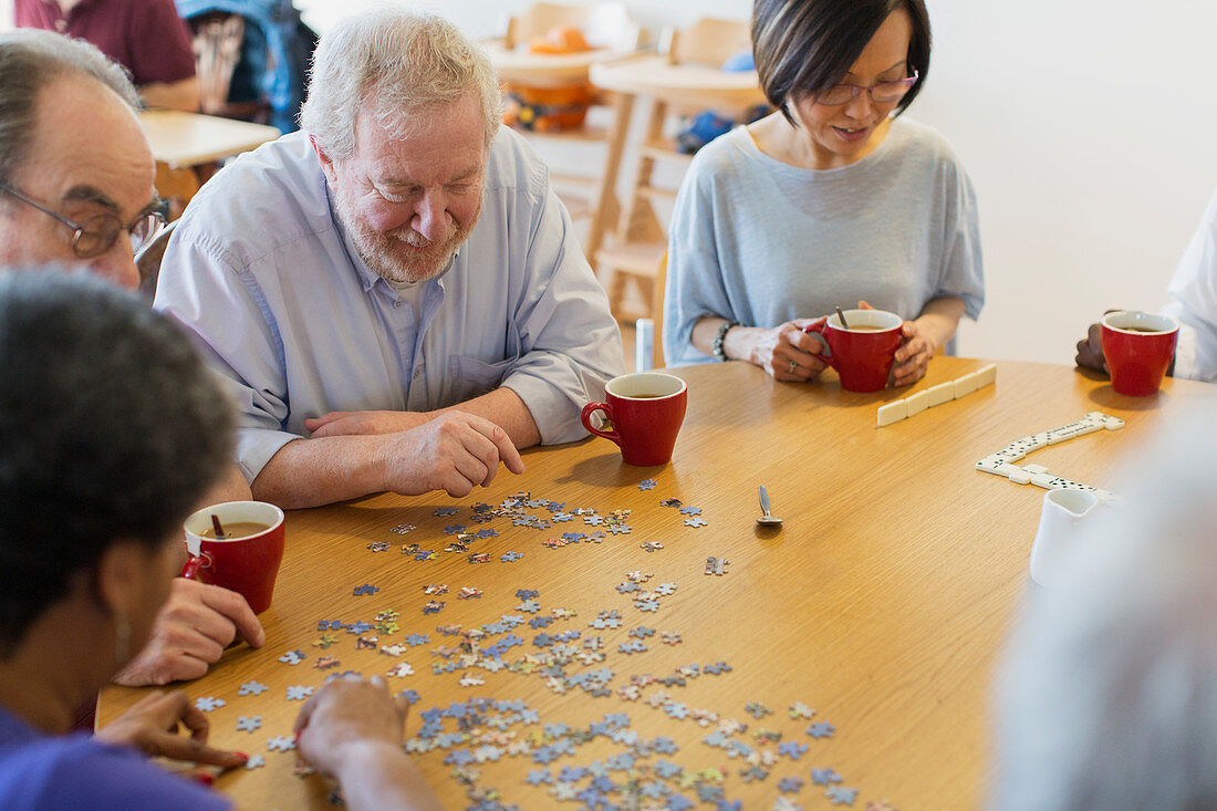Senior friends assembling jigsaw puzzle