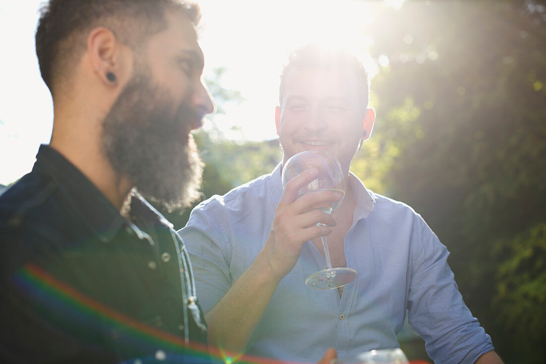 Male gay couple drinking wine and talking