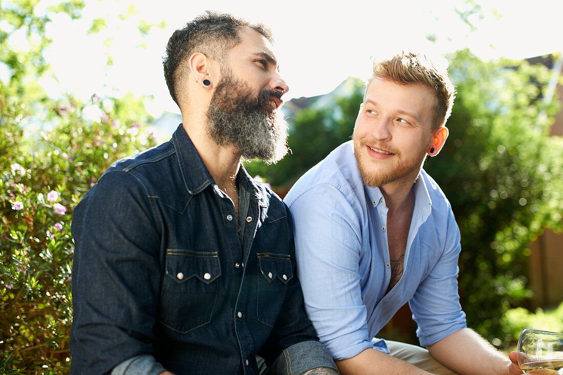 Male gay couple talking in garden