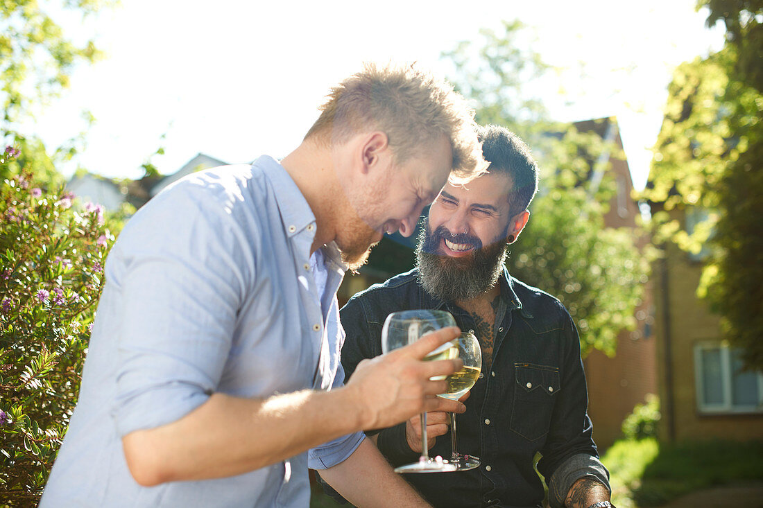 Happy male gay couple drinking wine