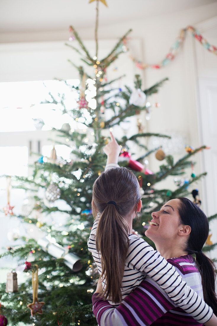 Affectionate mother and daughter looking up tree