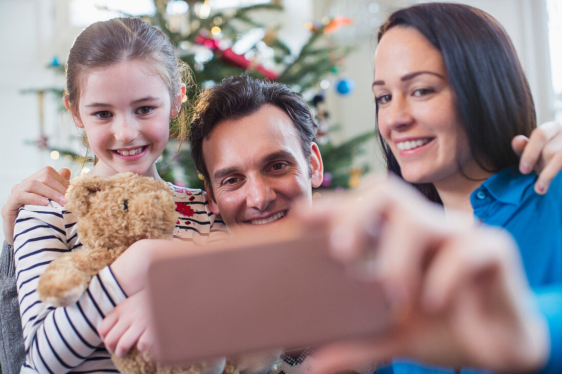Happy family with smart phone taking selfie