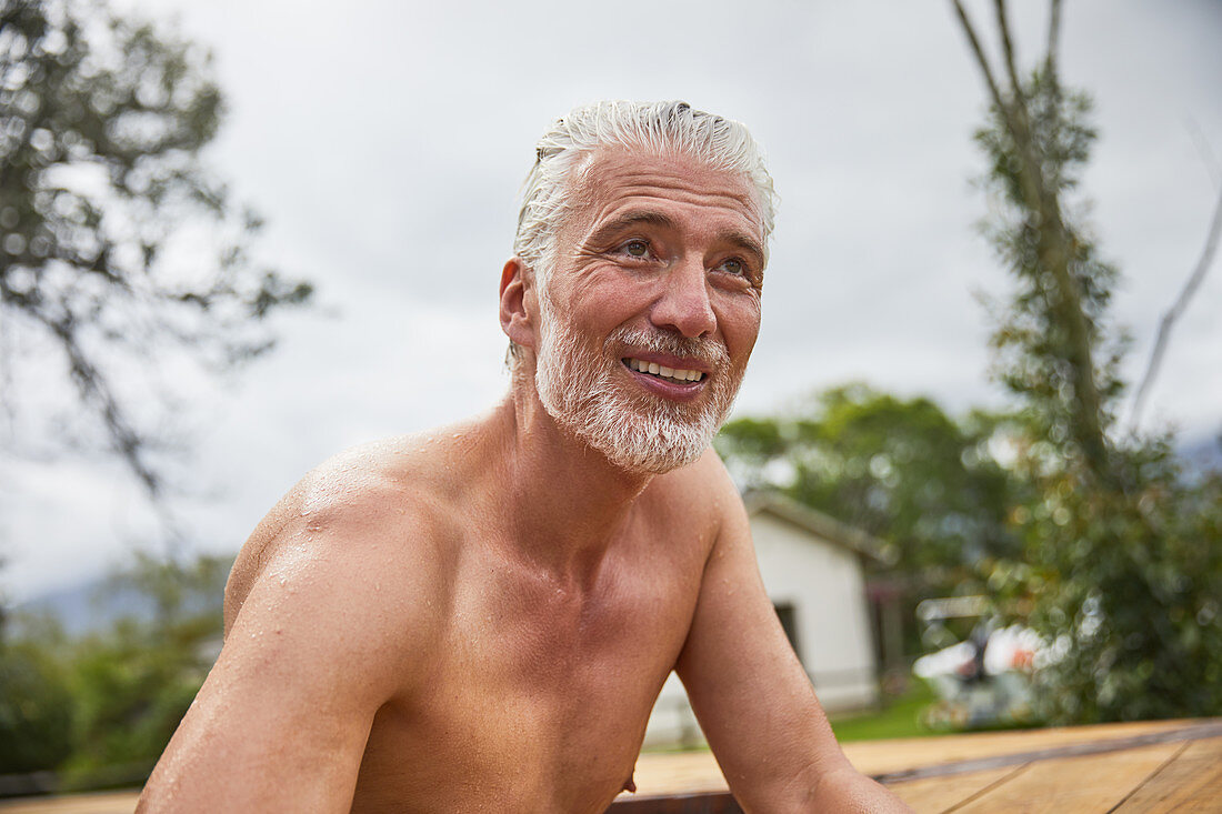Portrait mature man in hot tub summer deck