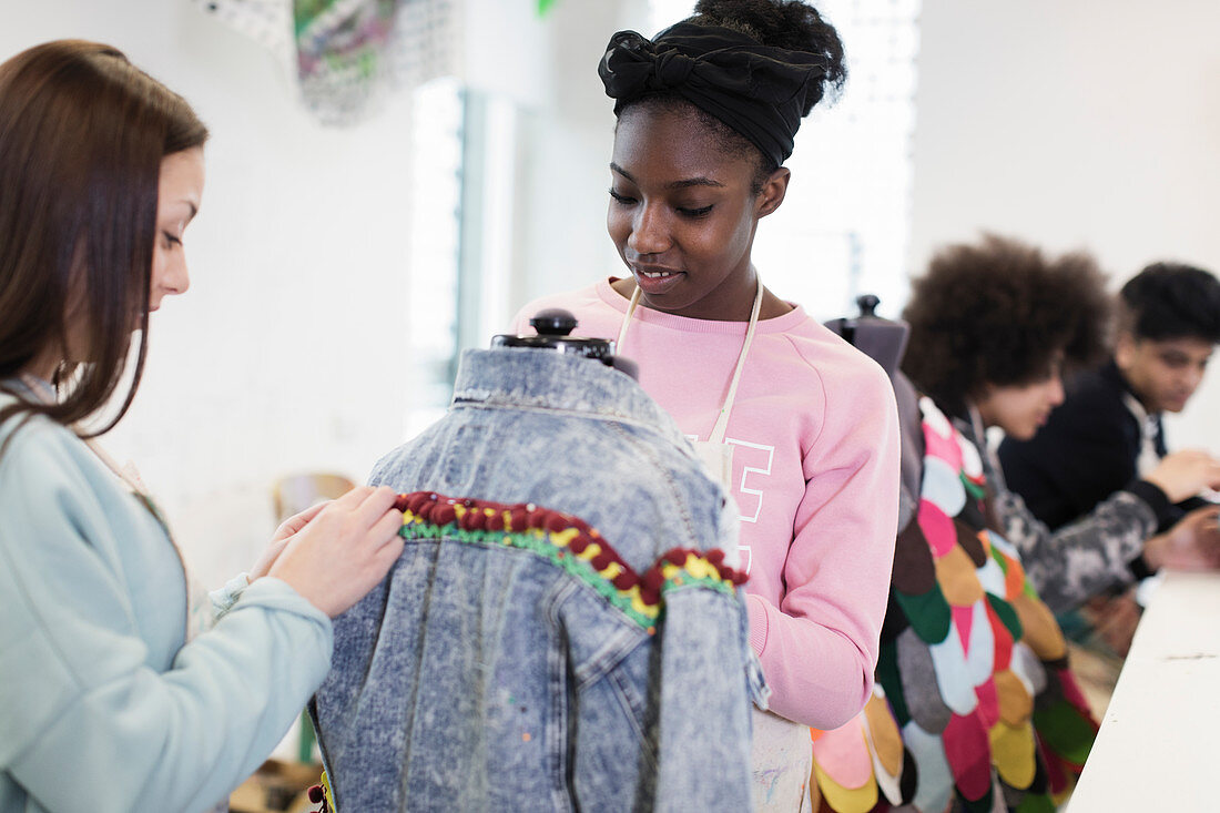 Teenage girls designing denim jacket