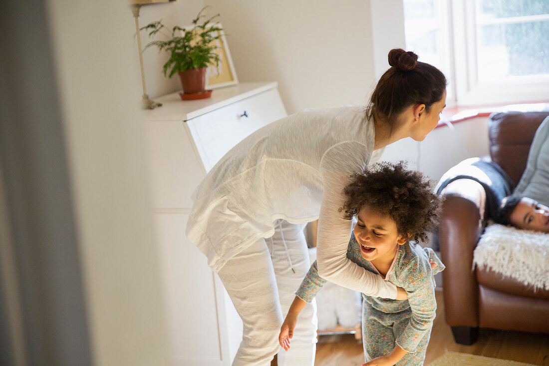 Playful mother and daughter in pyjamas