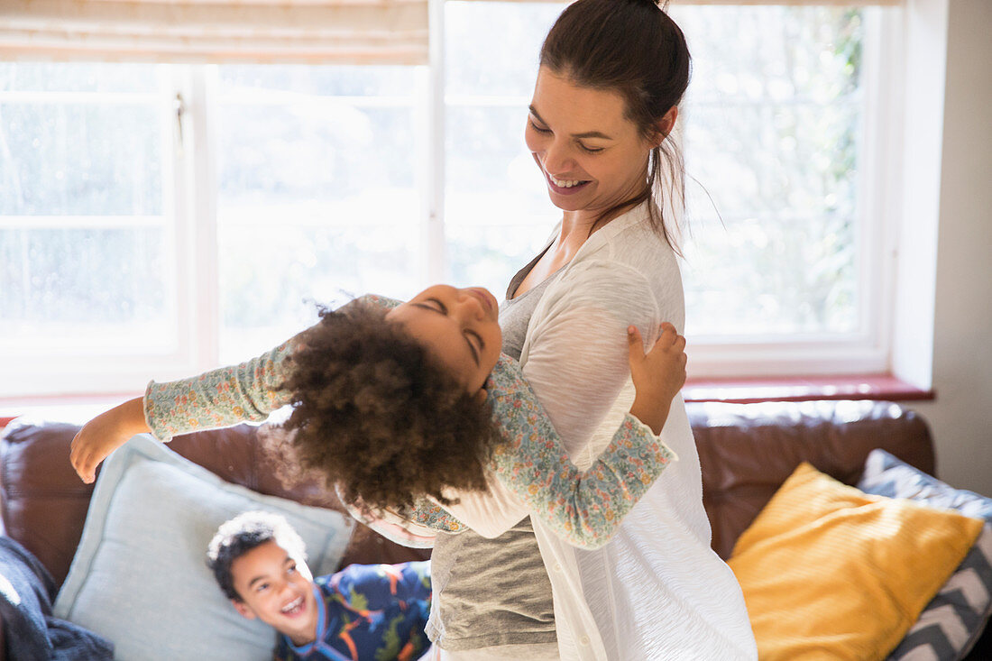 Playful mother and daughter in living room