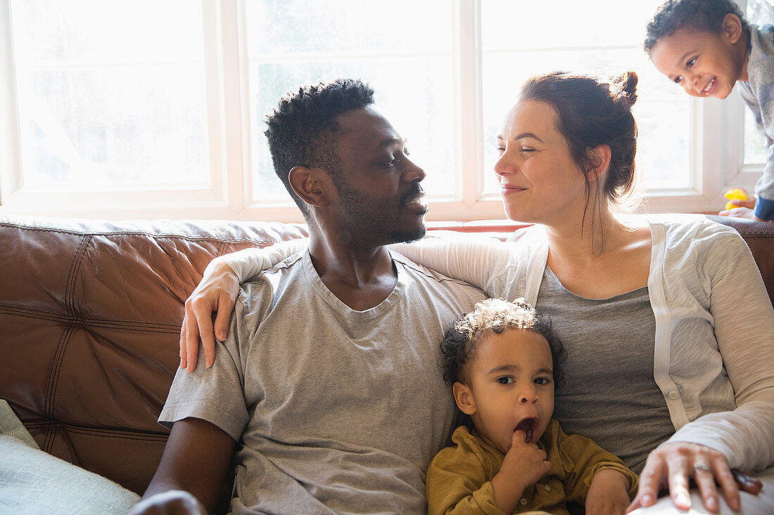 Affectionate multi-ethnic young family on sofa
