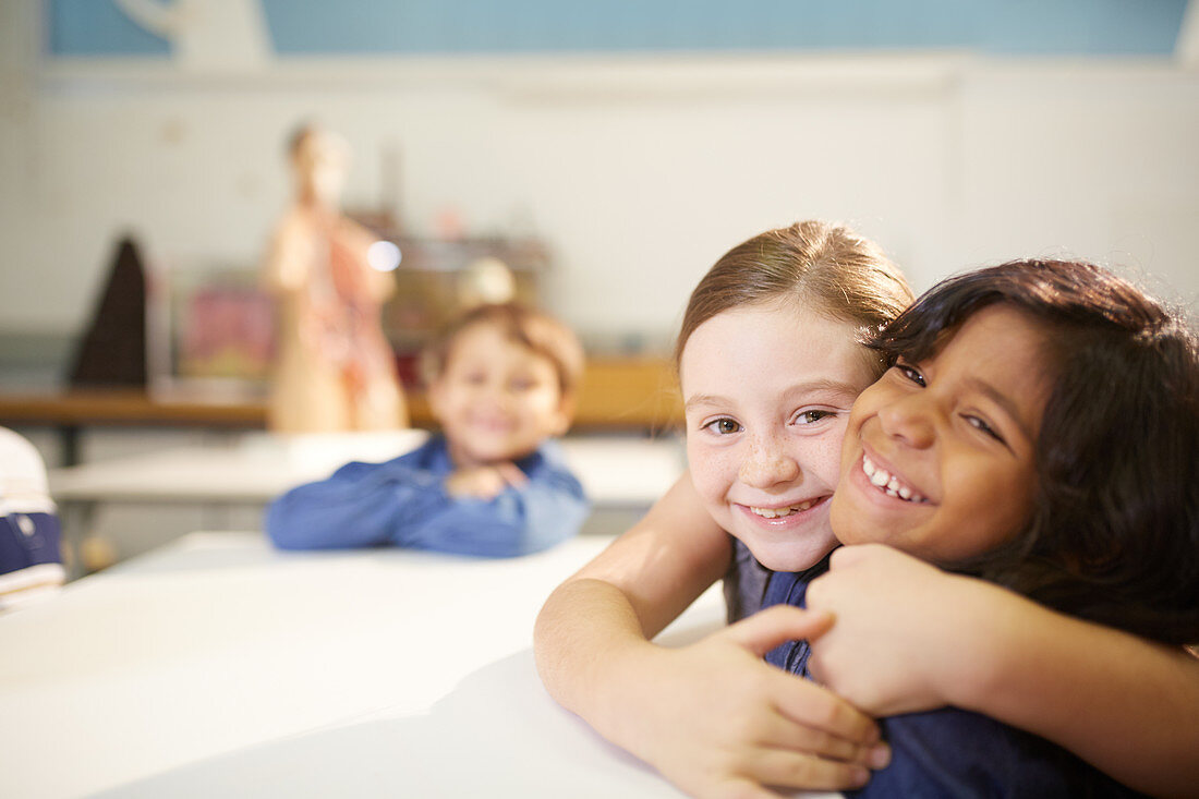 Portrait affectionate, cute schoolgirls hugging