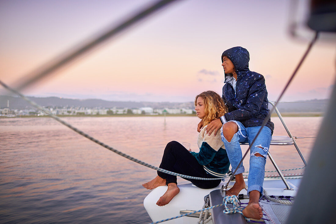 Young couple relaxing on boat at sunset