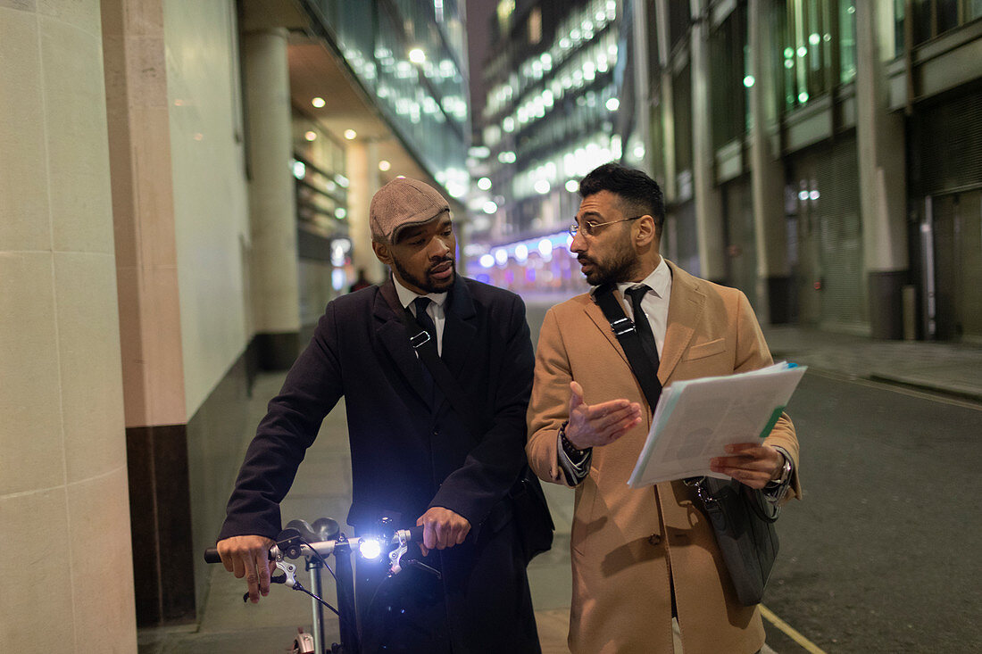 Businessmen with bicycle and paperwork walking