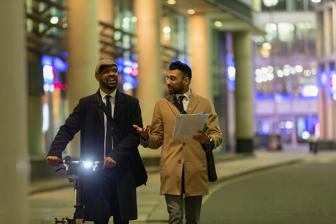 Businessmen talking, discussing paperwork at night