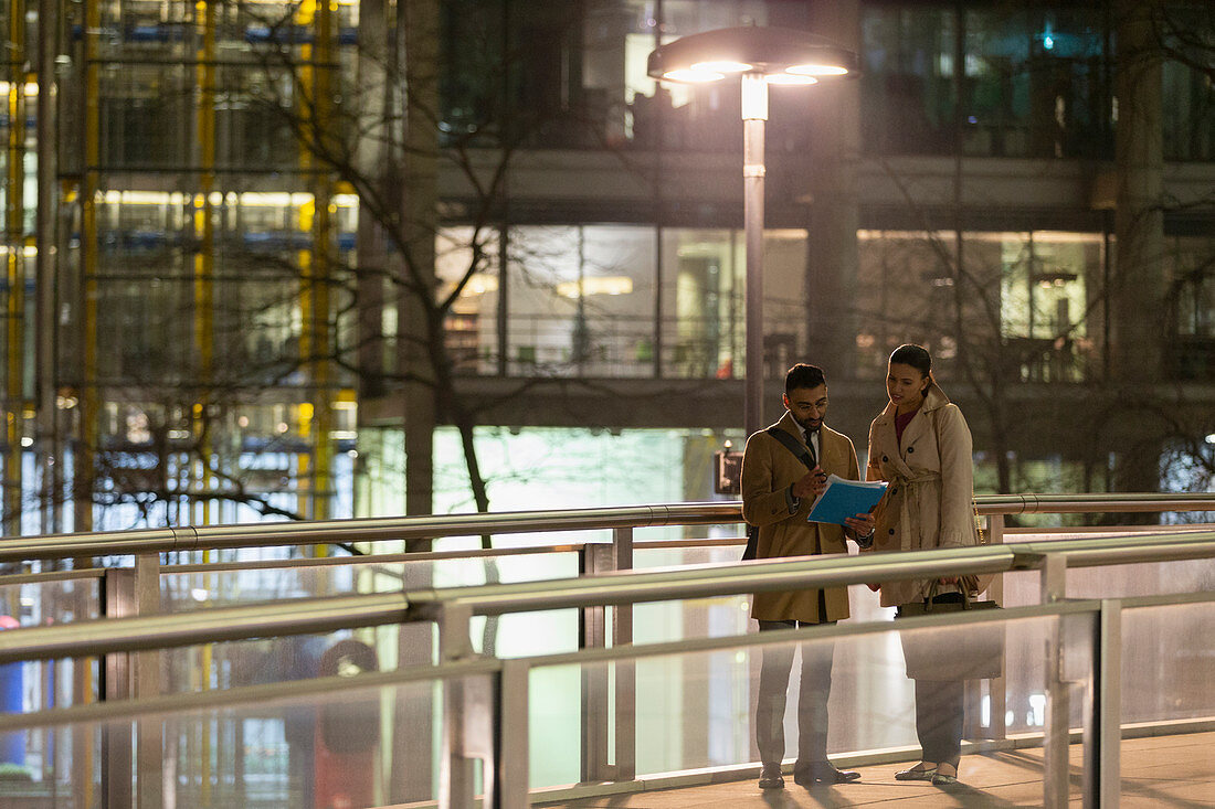 Business people on bridge at night