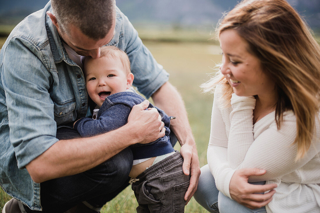 Parents hugging baby son