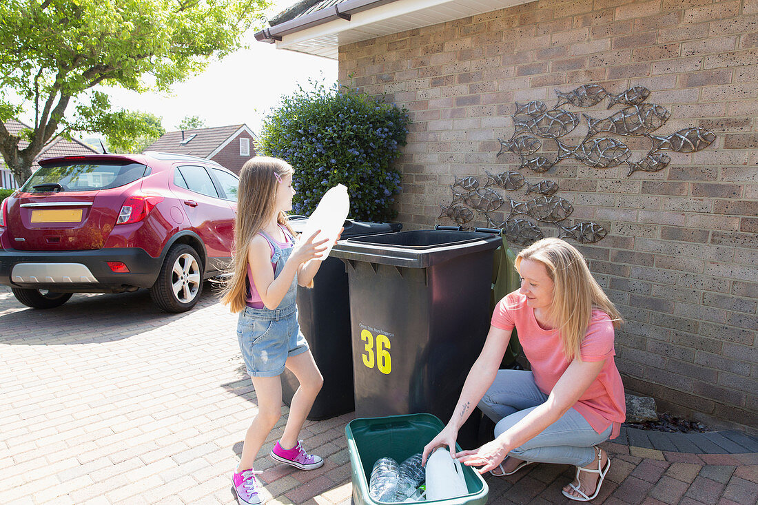 Mother and daughter recycling plastic