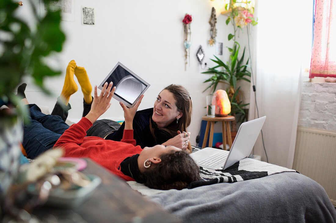 Young women friends relaxing on bed