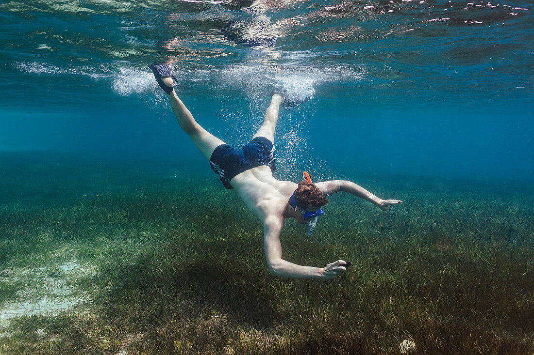Young man snorkelling underwater