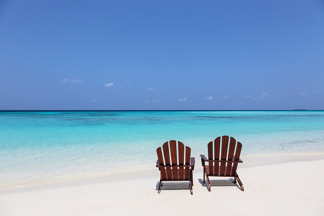 Two adirondack chairs on beach