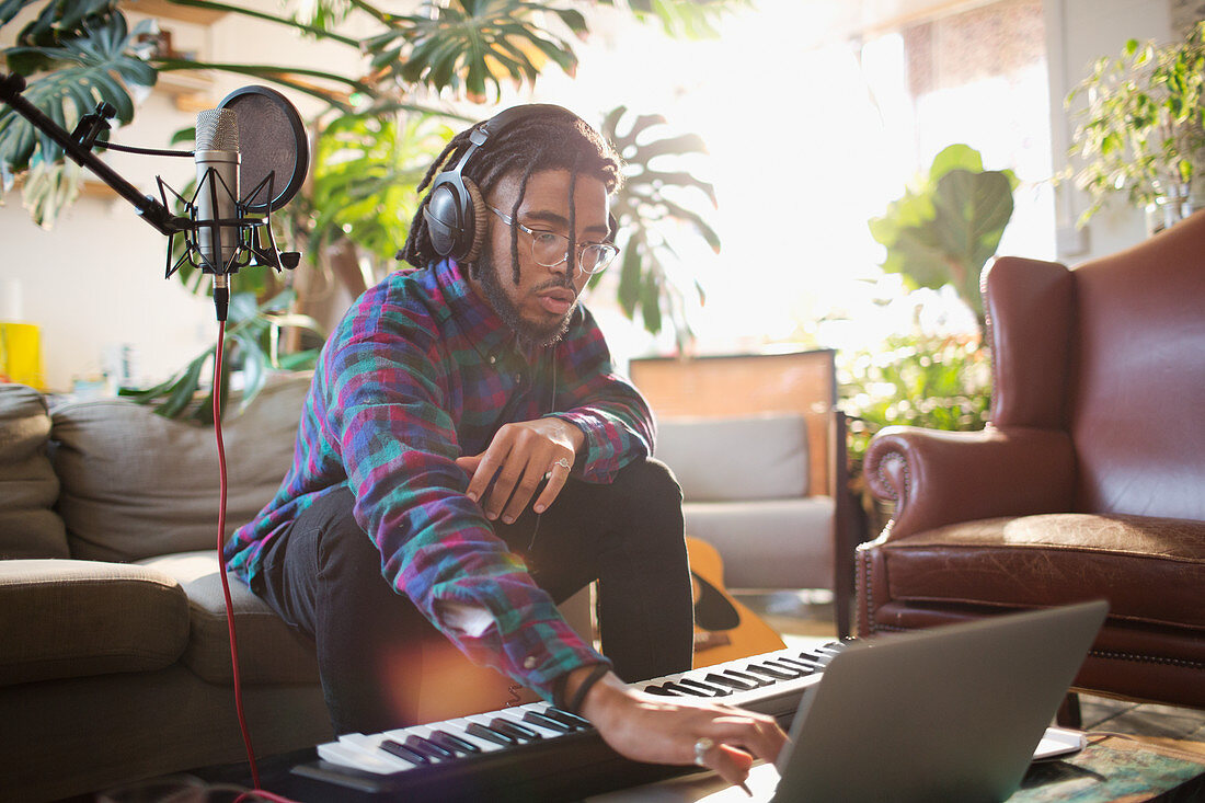 Musician recording music, using laptop