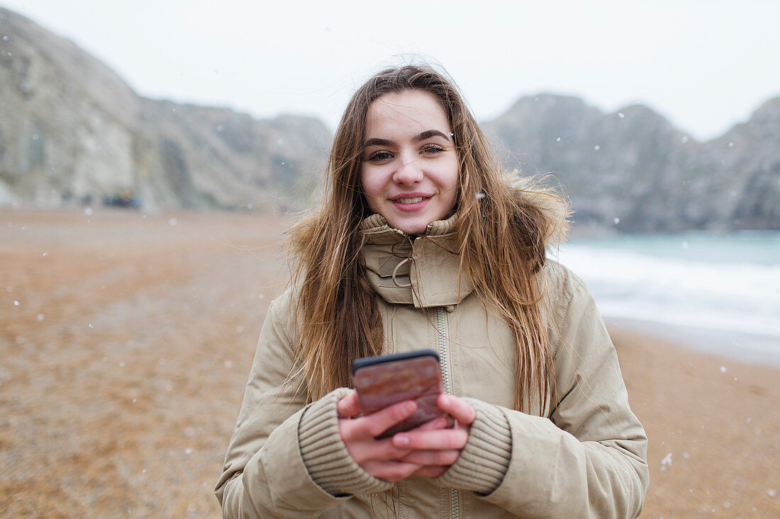 Portrait girl texting with smart phone on beach