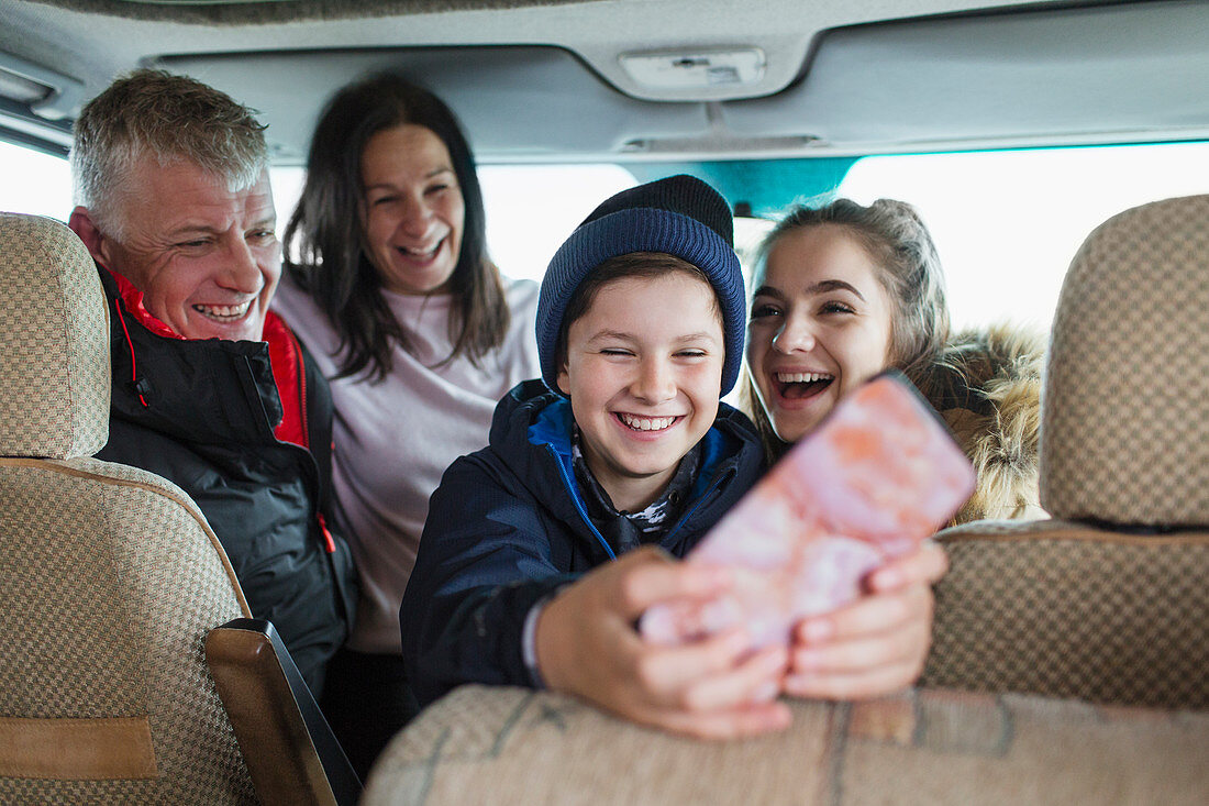 Happy family with smart phone in motor home