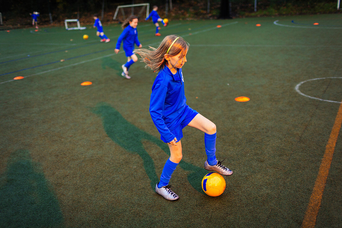Girl practicing soccer drill