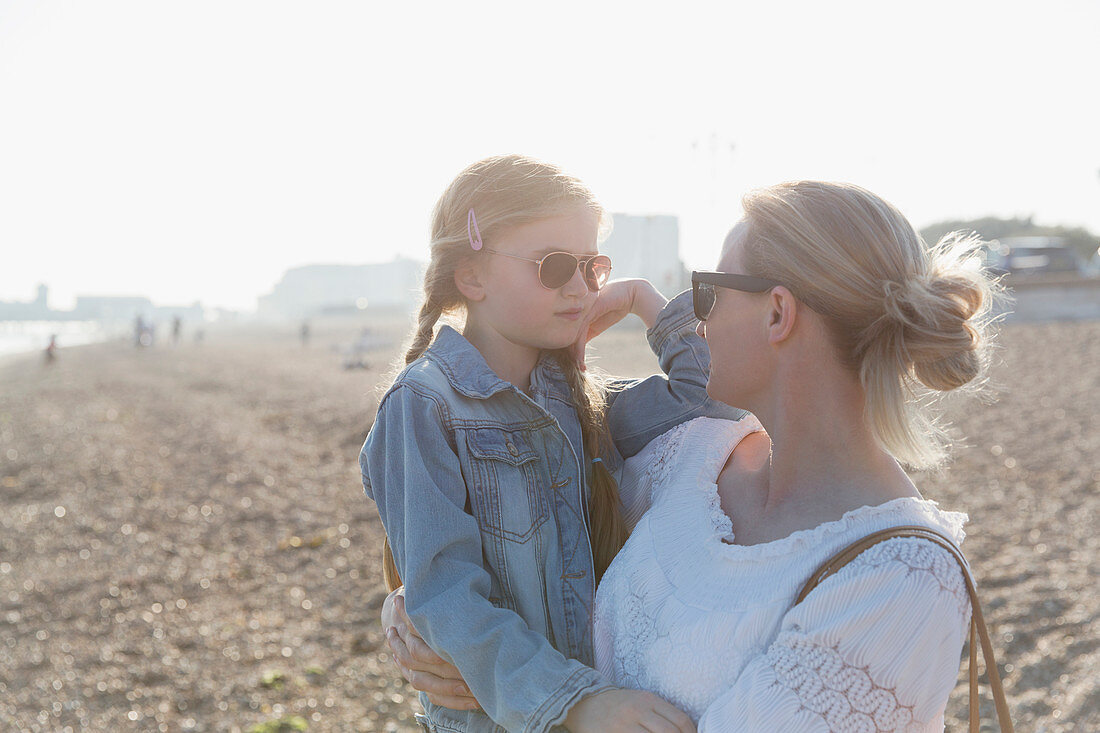 Mother and daughter wearing sunglasses on beach