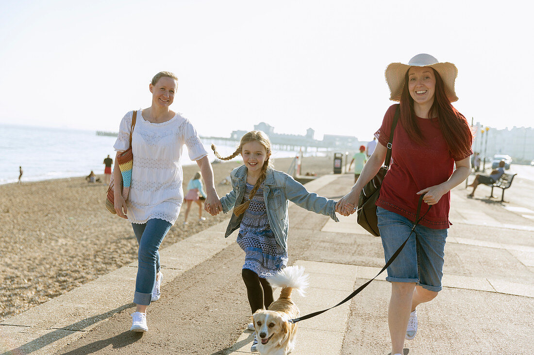 Lesbian couple walking with daughter and dog