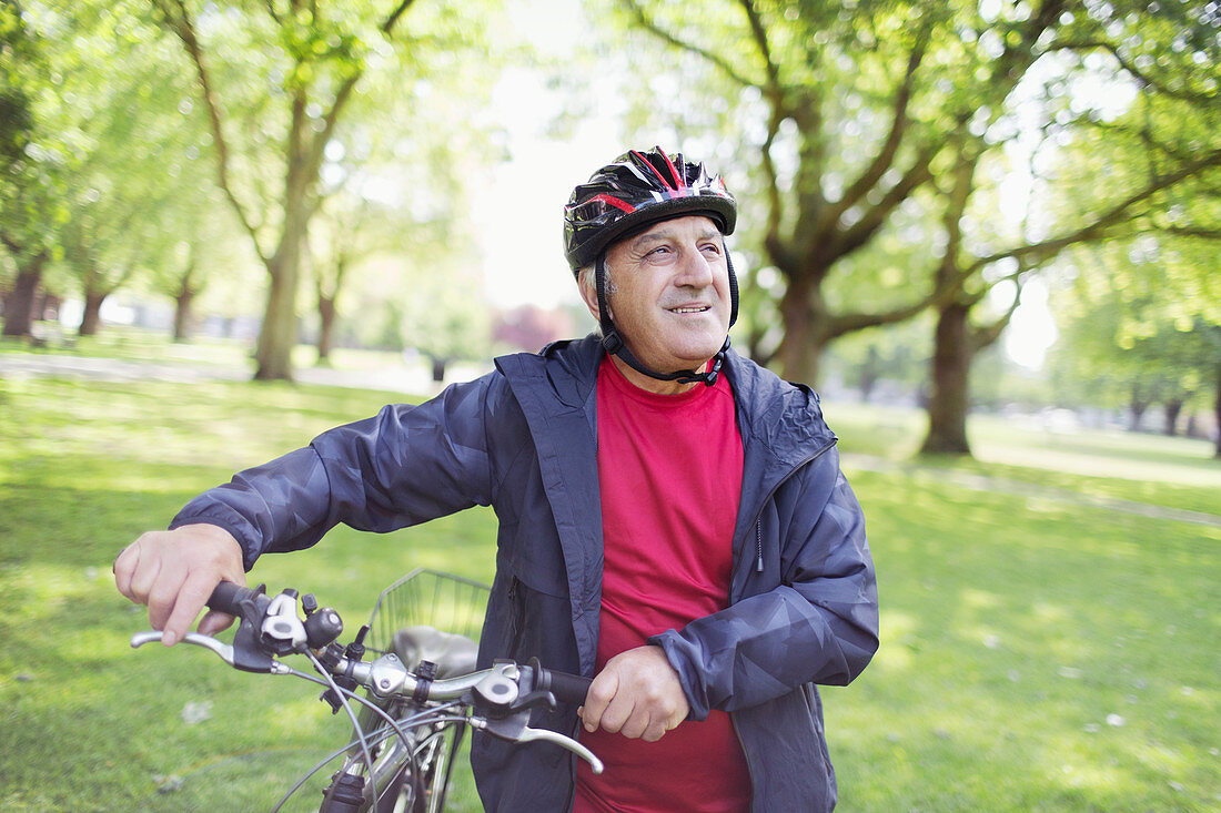 Active senior man riding bike in park