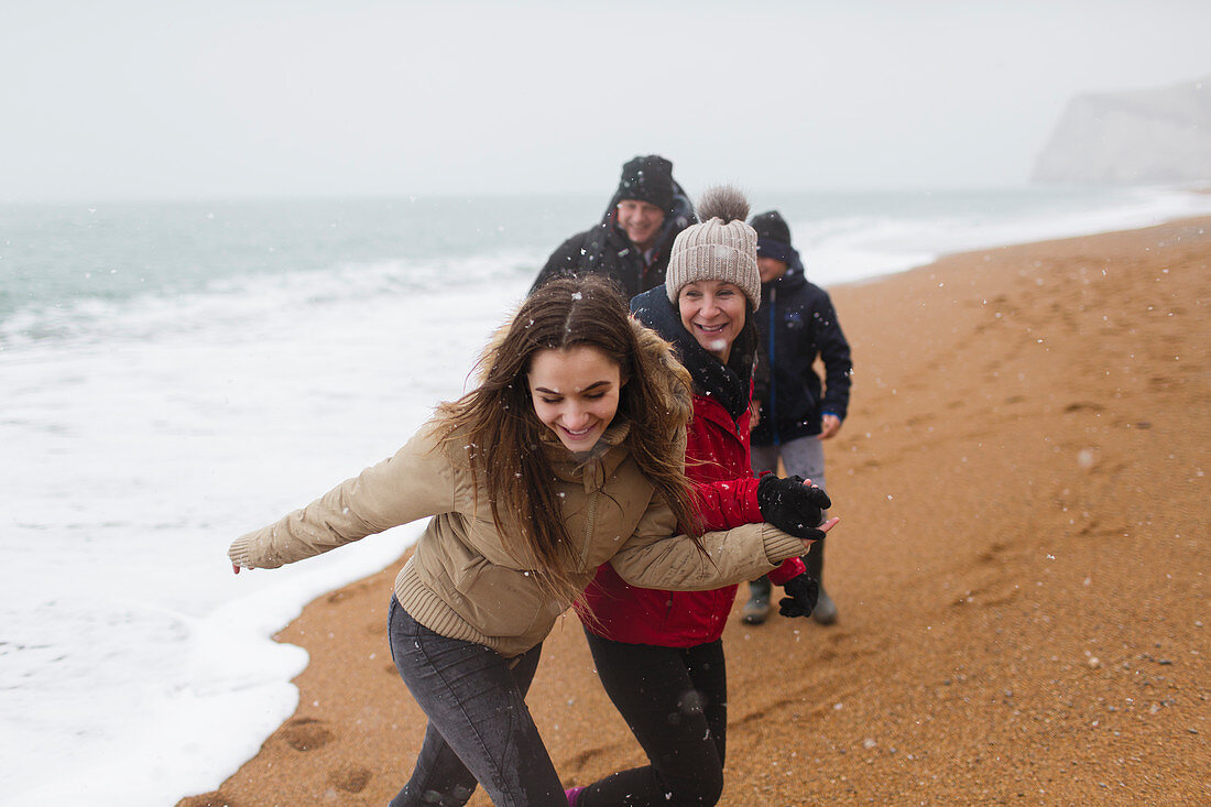 Happy, carefree family on snowy winter beach