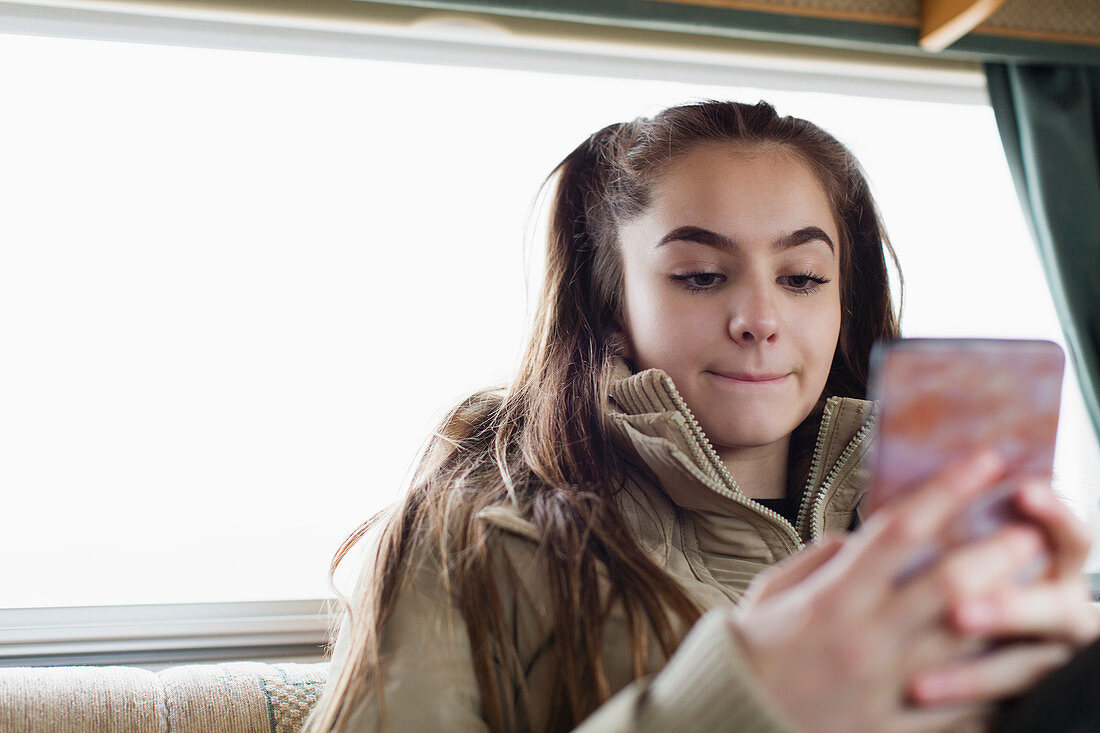 Teenage girl texting with smart phone