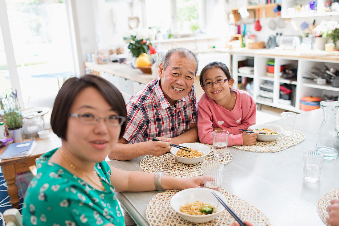 Portrait Family eating noodles with chopsticks