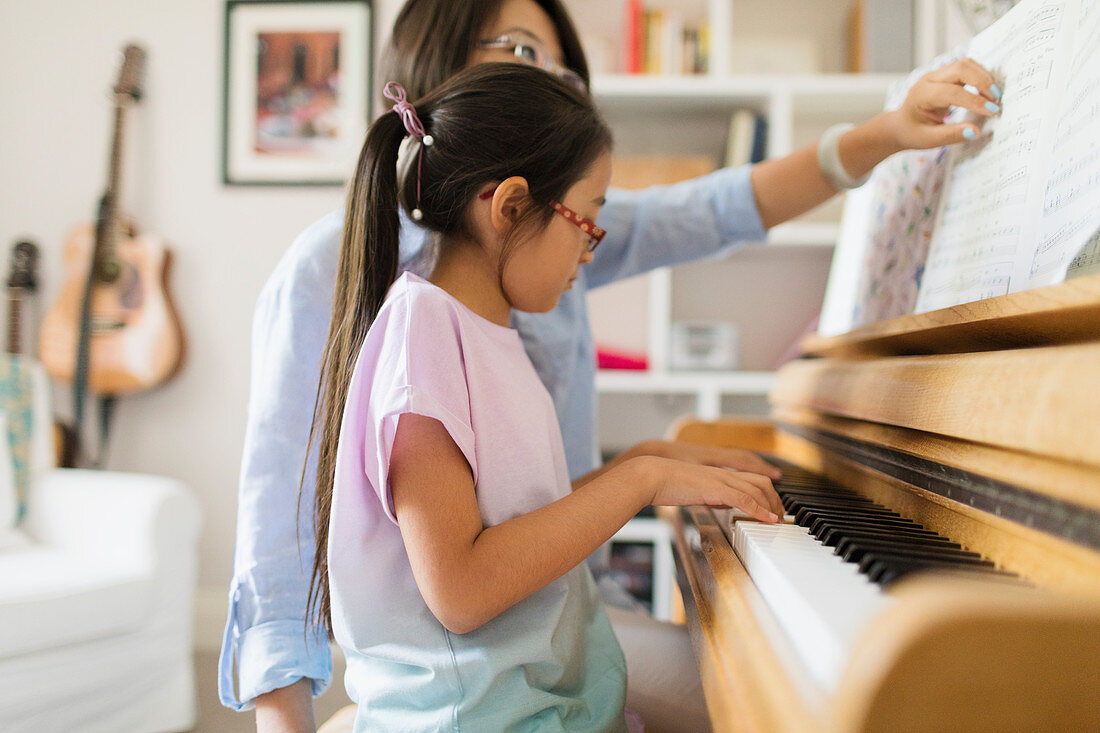 Mother and daughter playing piano