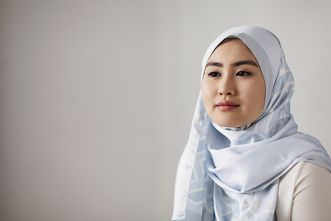 Portrait woman in blue silk hijab looking away