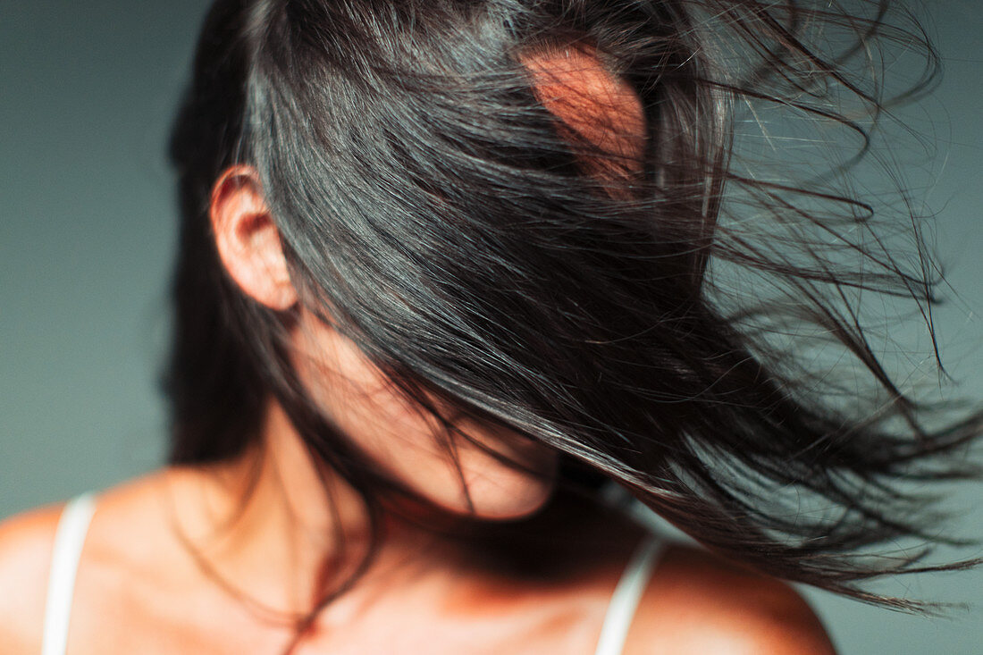 Wind blowing hair in woman's face