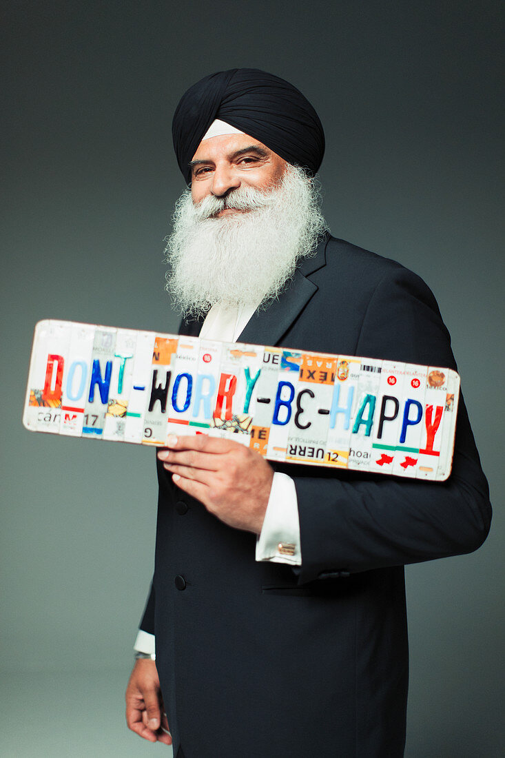 Man in turban holding license plates