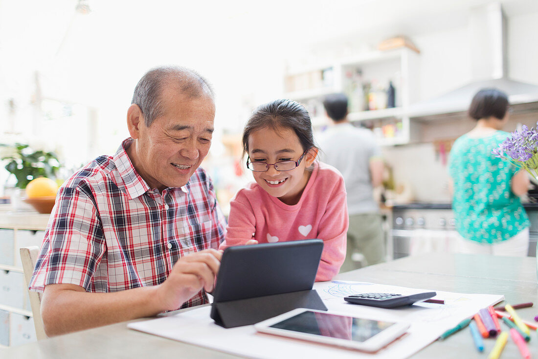 Grandfather and granddaughter using tablet