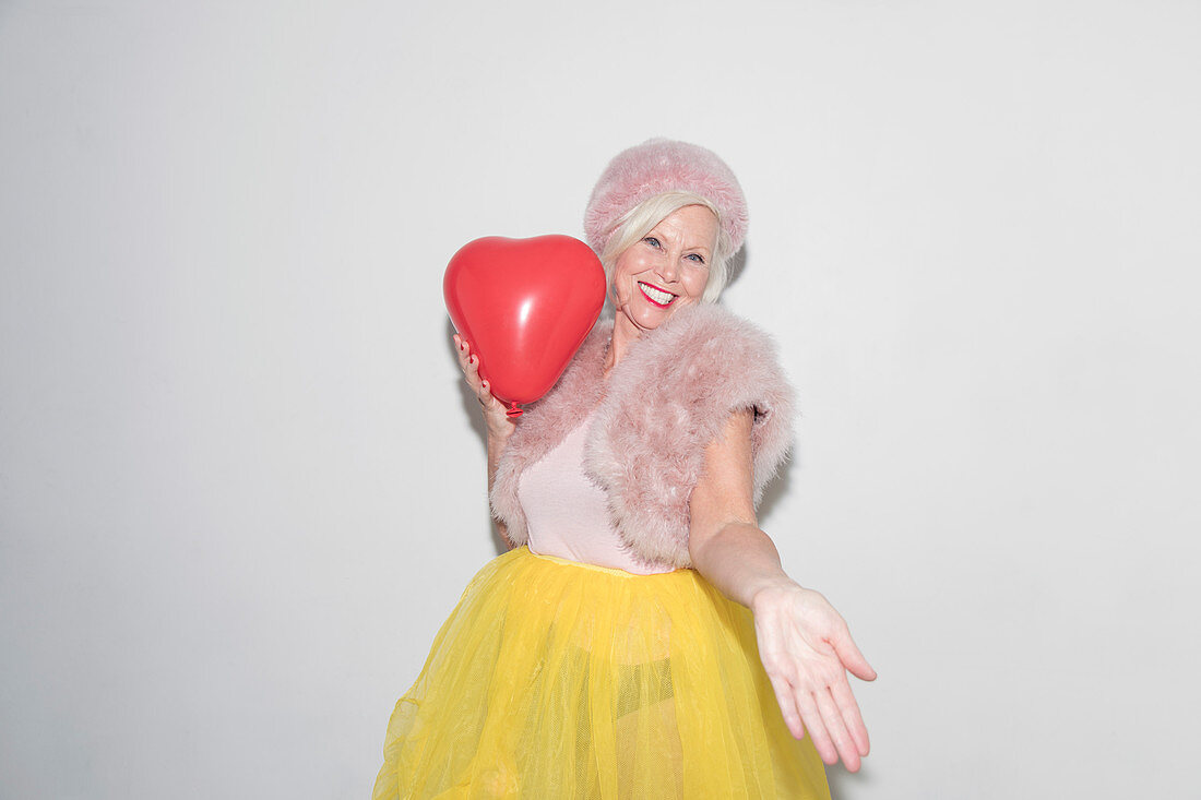 Senior woman with heart-shape balloon