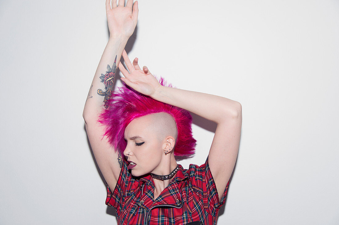 Young woman with pink mohawk dancing