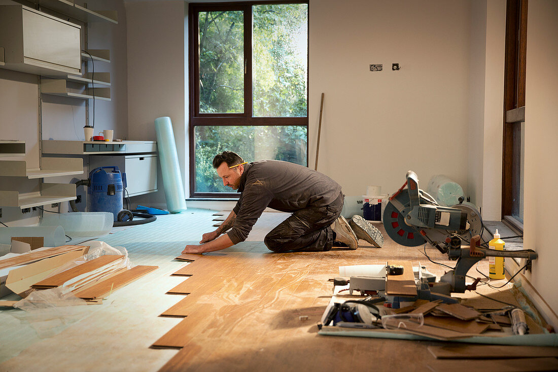 Construction worker laying hardwood flooring